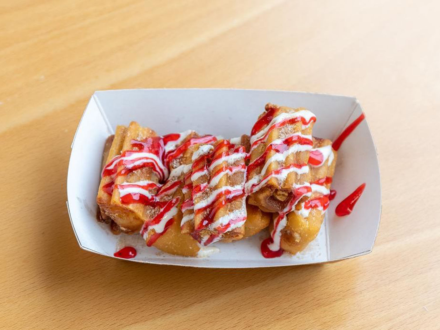 Churros with strawberry and cream drizzle at Fusion Poke, an Asian Fusion Restaurant in Milwaukee