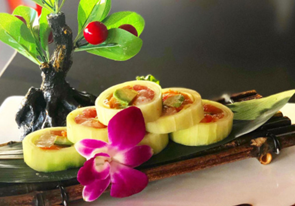 Cucumber wrapped sushi rolls garnished with purple orchid and miniature bonsai tree on bamboo platter at Tony Fusion West, a Asian Fusion Restaurant in Westhampton Beach