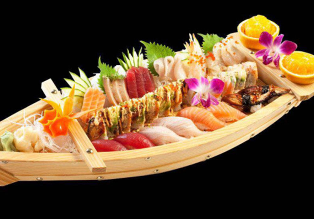 Large wooden sushi boat platter filled with assorted sashimi, nigiri, maki rolls and edible flower garnishes at Tony Fusion West, a Asian Fusion Restaurant in Westhampton Beach