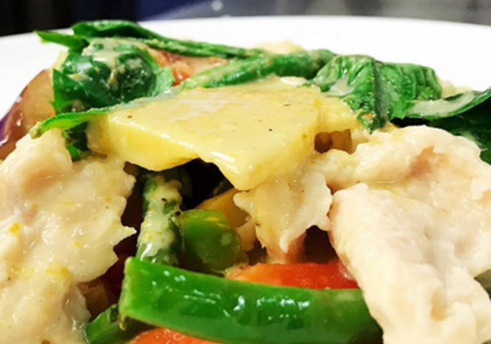 Creamy stir-fried chicken with green beans, basil and pineapple chunks on white ceramic plate at Tony Fusion West, a Asian Fusion Restaurant in Westhampton Beach