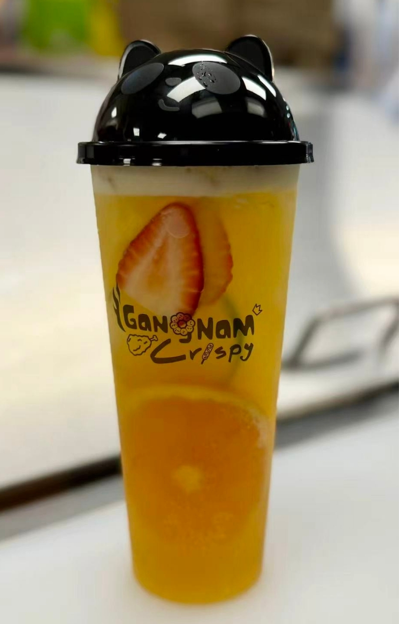 Bright citrus tea with strawberry and orange slices in a cute cup at Gangnam Crispy, a Korean Restaurant in Toledo