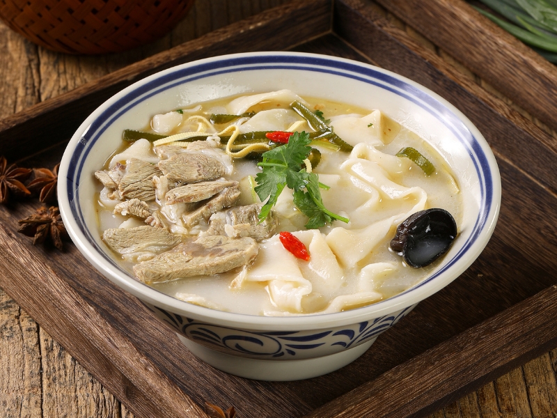 Hearty beef noodle soup with wide noodles and tender beef slices at Gao Qunsheng's Spicy Soup, a Chinese Restaurant in Flushing