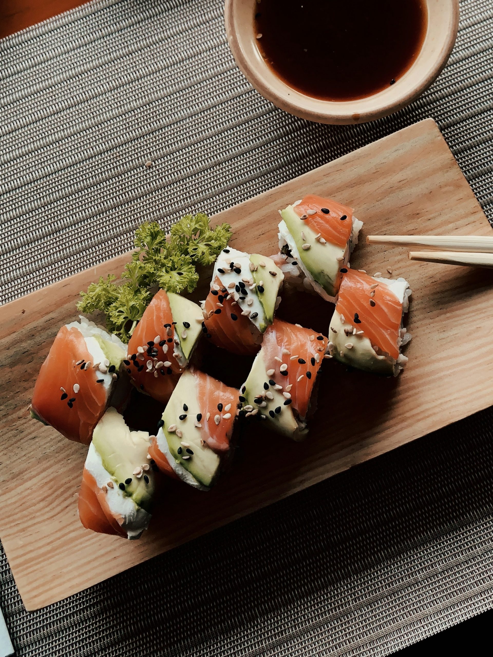 Fresh salmon avocado sushi rolls on wooden board with soy sauce at Golden Dragon Restaurant, a Chinese Restaurant in East Troy Fresh salmon avocado sushi rolls on wooden board with soy sauce at Golden Dragon Restaurant, a Chinese Restaurant in East Troy