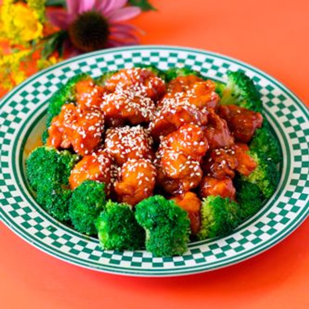 Sesame coated chicken chunks with broccoli on checkered plate at Golden Dragon Restaurant, a Chinese Restaurant in East Troy