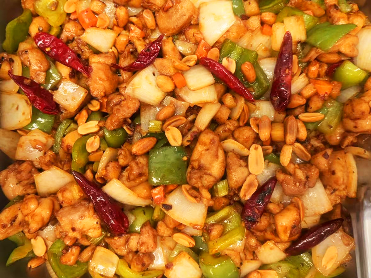 A close - up of Kung Pao Chicken with chicken pieces, peanuts, peppers, and onions at Golden Dragon，a Asian Fusion Restaurant in Newman