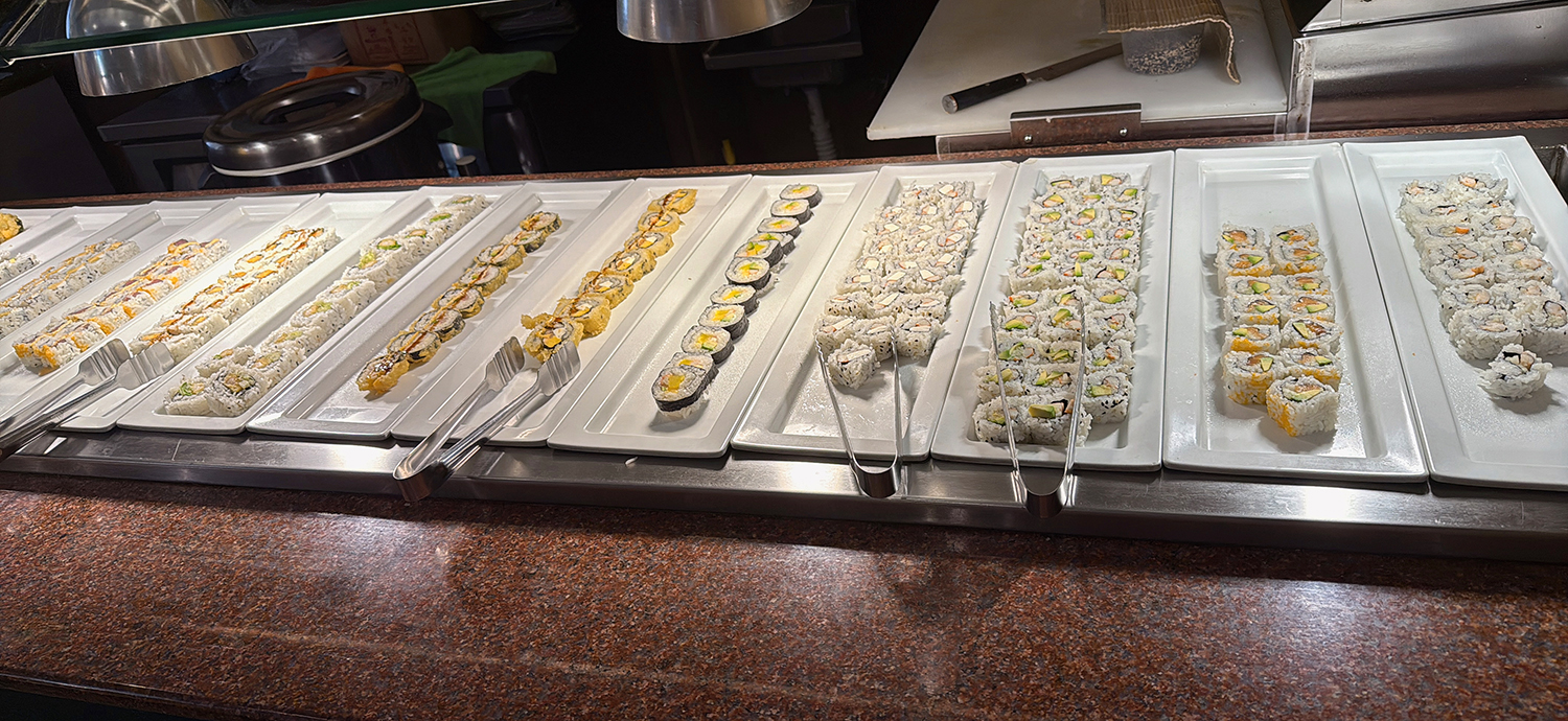 Array of various sushi rolls on white platters with serving tongs at Golden Wok，a Chinese Restaurant in Weaverville