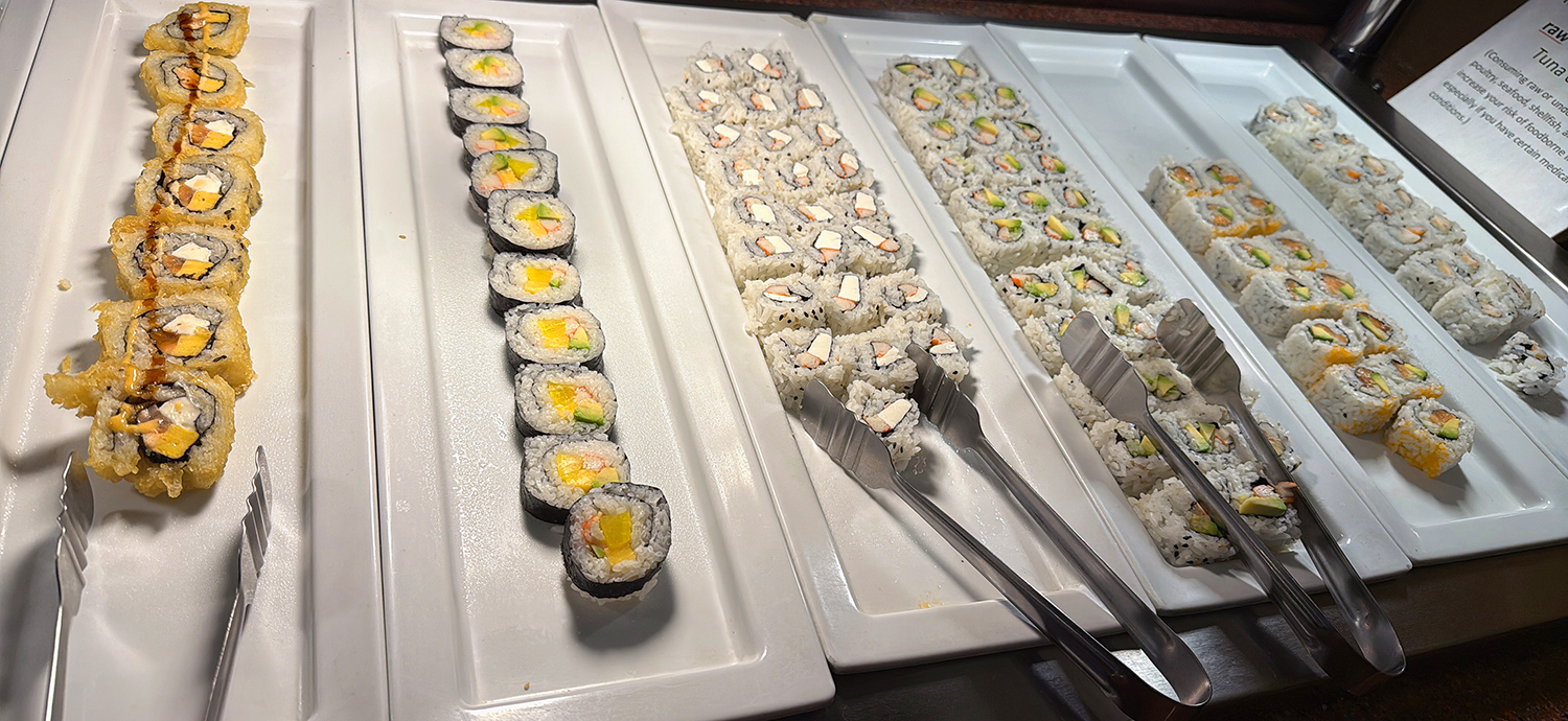 Different types of sushi rolls on white trays, with serving tongs available at Golden Wok，a Chinese Restaurant in Weaverville