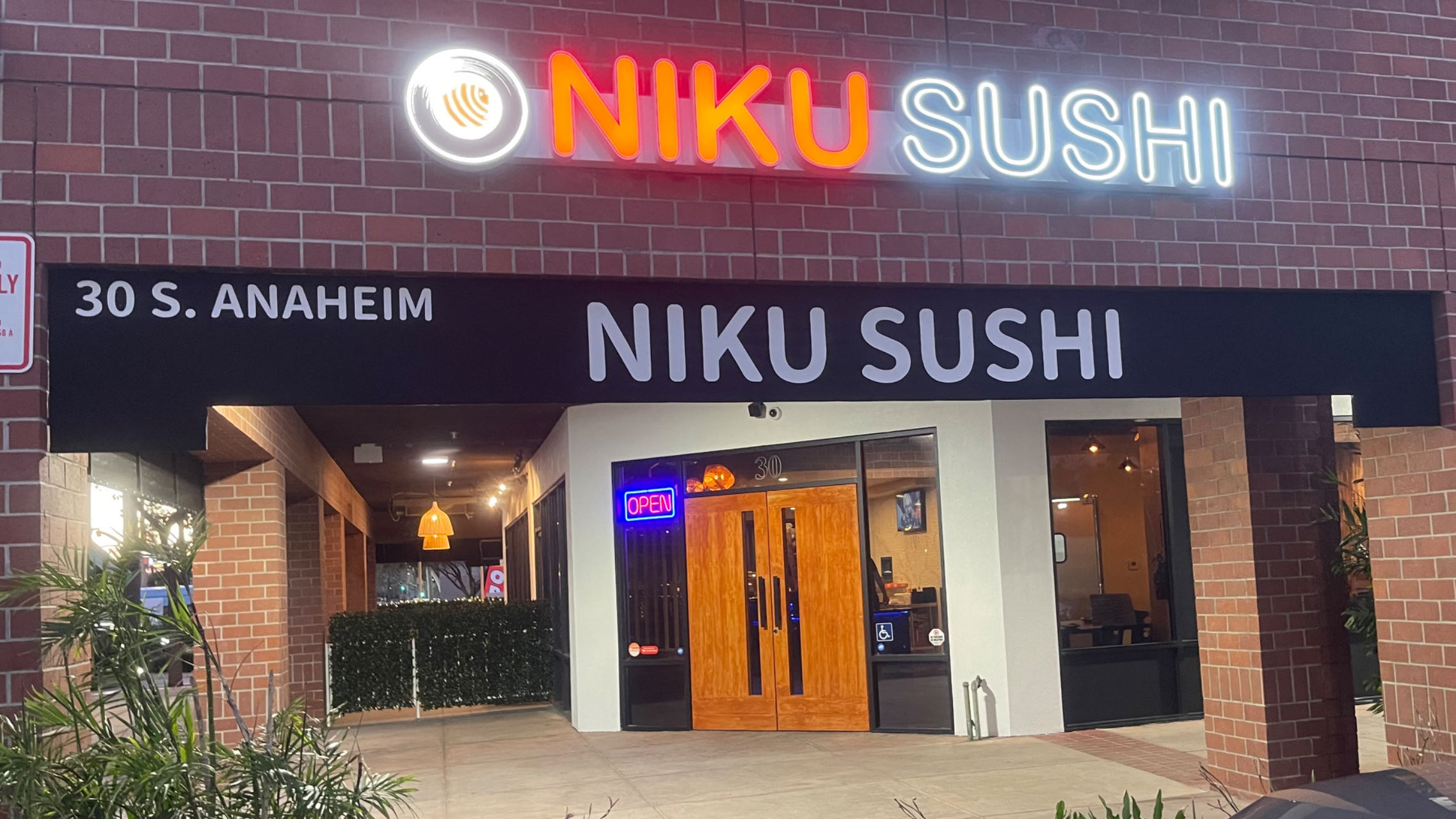 This is the exterior of Niku Sushi restaurant with the neon sign of the restaurant's name at Niku Sushi, a Japanese restaurant in Anaheim