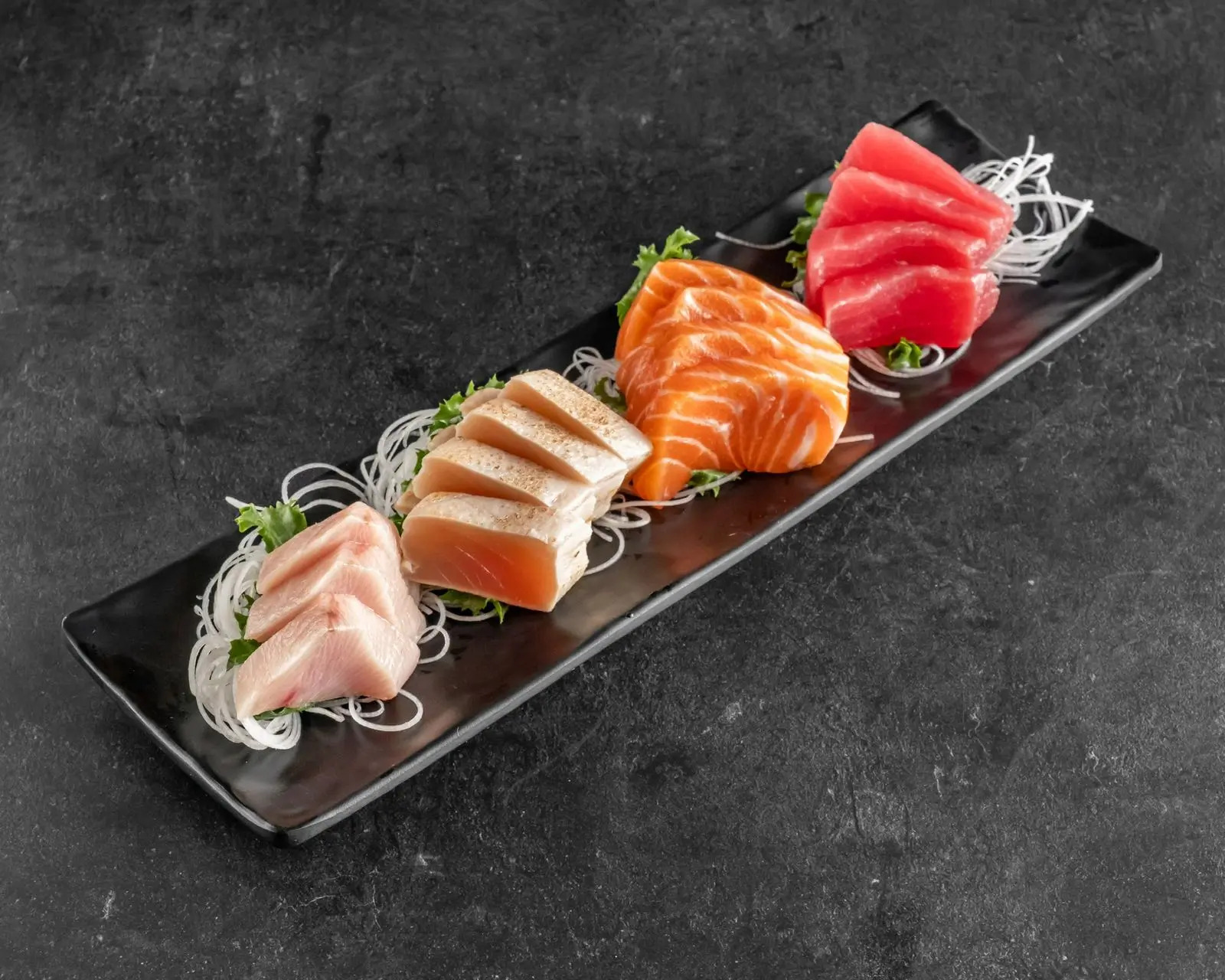Platter of fresh sashimi varieties on shredded radish at Niku Sushi, a Japanese restaurant in Anaheim