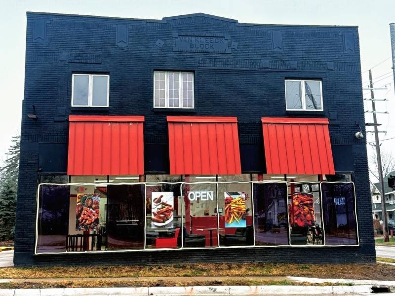 Storefront of Grab Crab with food posters at Grab Crab, a Seafood Restaurant in Pontiac