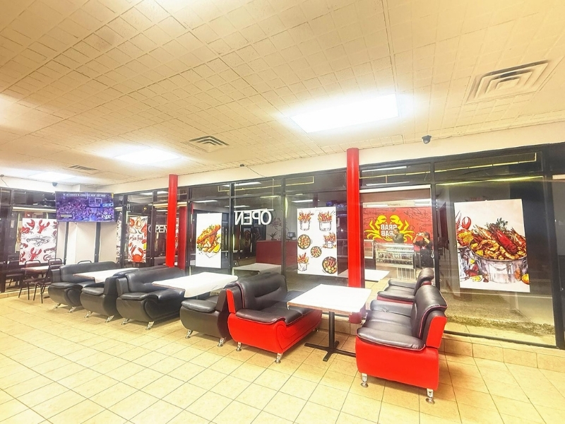 Dining area with tables and posters at Grab Crab, a Seafood Restaurant in Pontiac