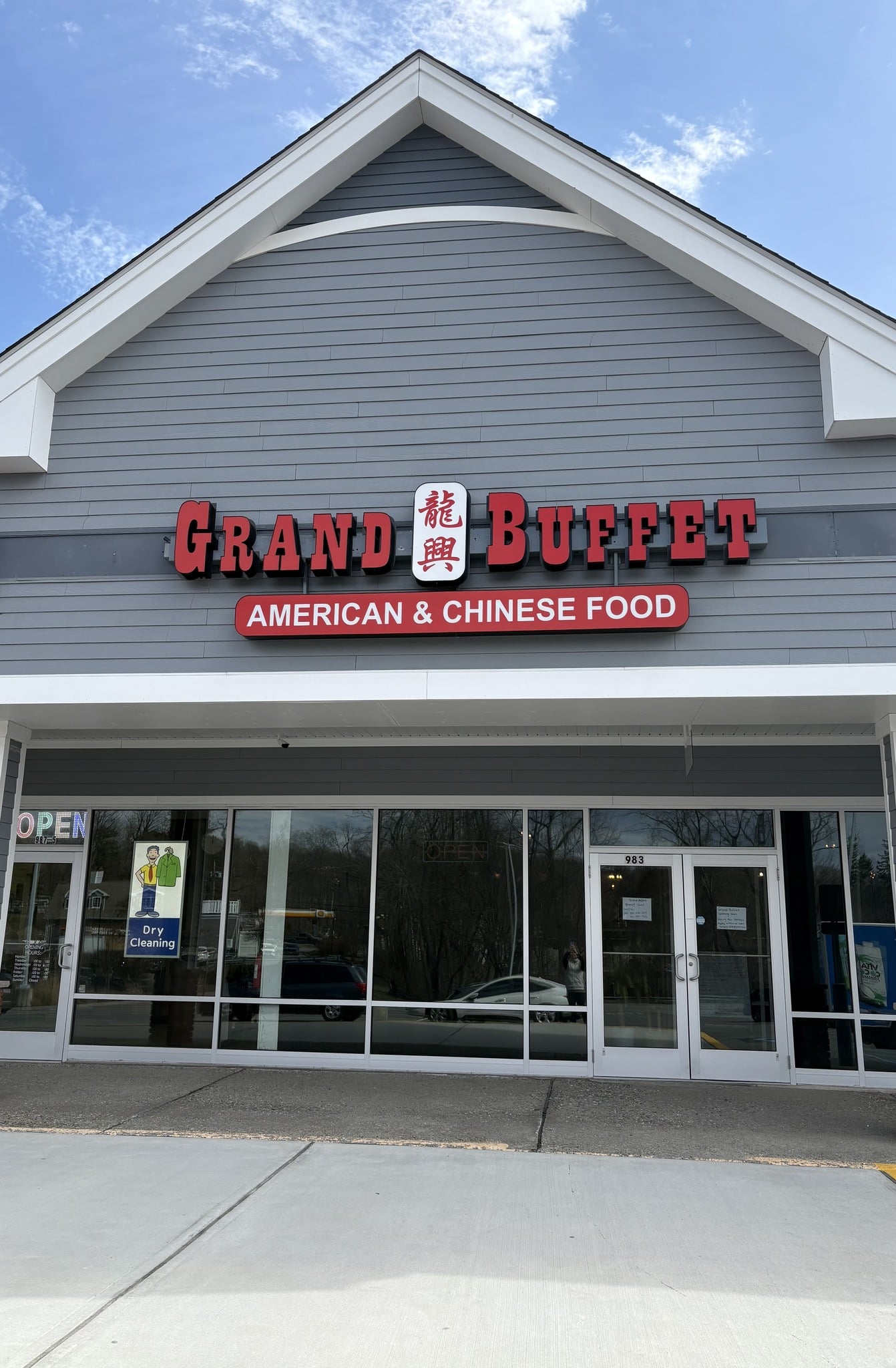 The exterior of Grand Buffet restaurant with a signboard indicating it serves American and Chinese food at Grand Buffet Restaurant in Mahopac