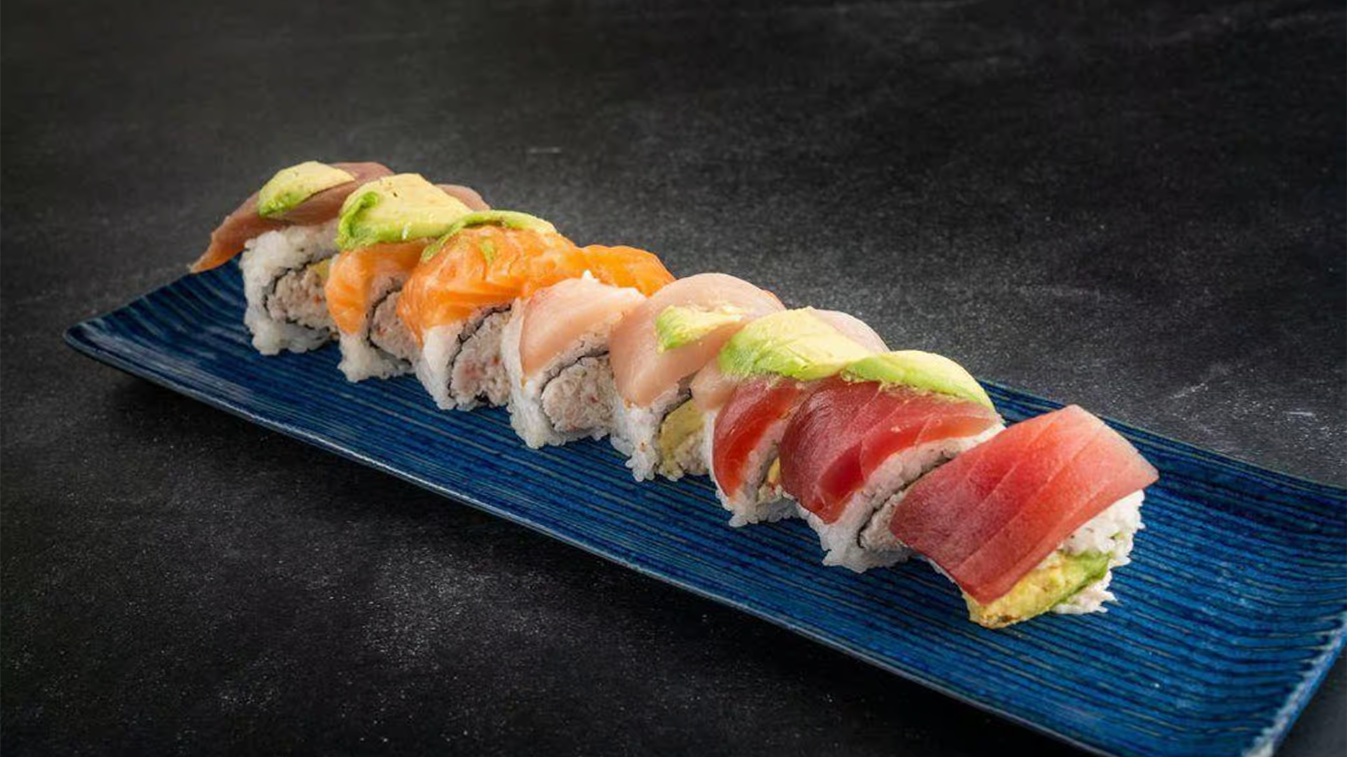 Colorful sushi roll with assorted fish and avocado at Haha Ramen Sushi, a Japanese restaurant in Hayward