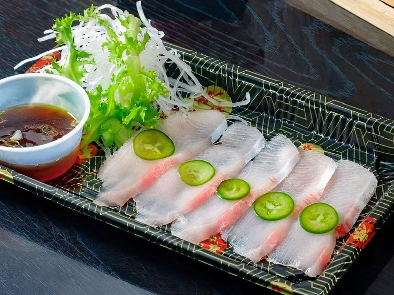 Slices of fresh white fish sashimi with condiments at Hana Sushi & Asian Cuisine, a Asian Restaurant in Maplewood