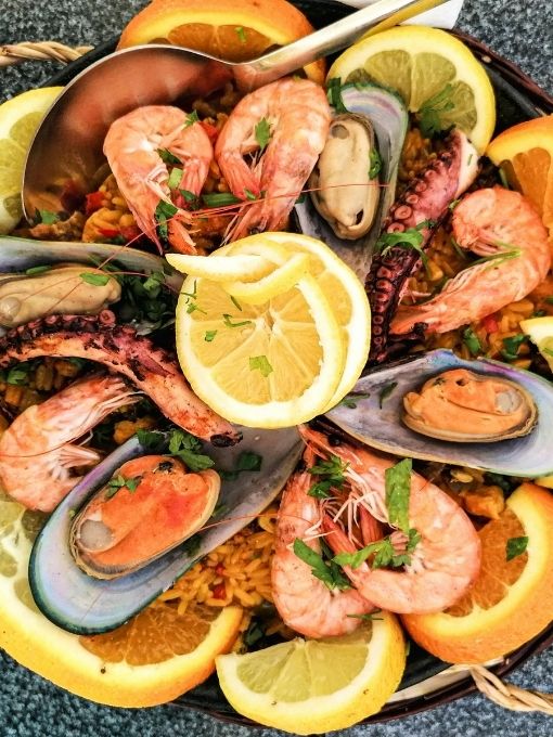 Seafood paella with shrimp, mussels, octopus, citrus slices, and herbs at Cherry Amber, a Asian fusion restaurant in Plainview