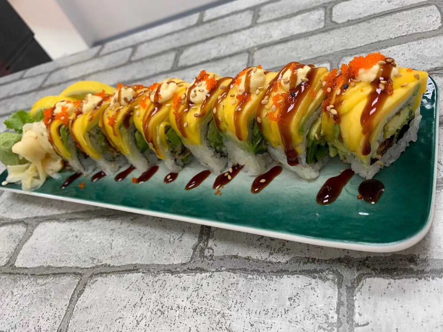 Sushi roll topped with fresh mango, sesame & sauce at Happy Canteen, a Japanese Restaurant in Brooklyn