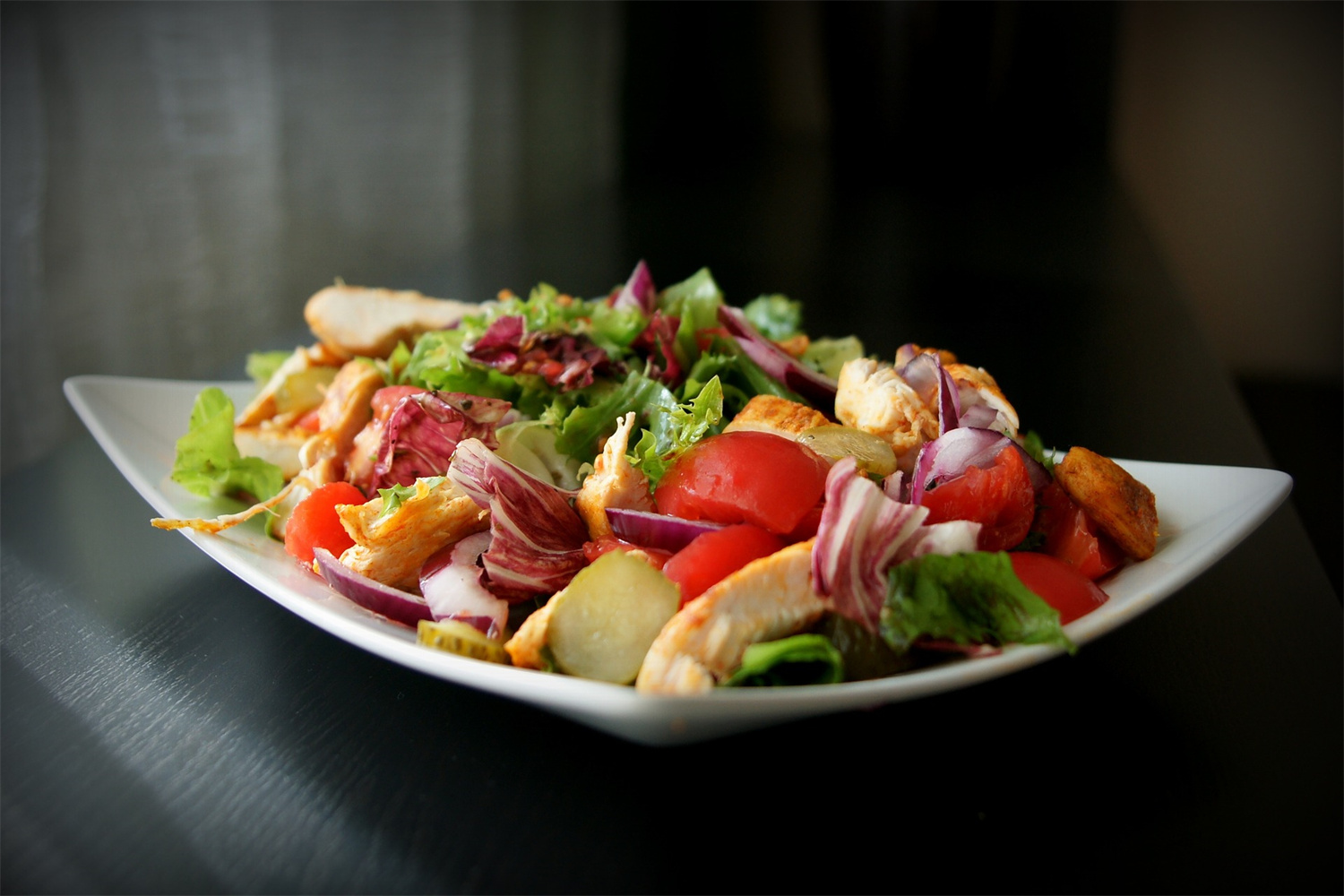 Fresh grilled chicken salad with mixed greens, cherry tomatoes, red onions, and vegetables