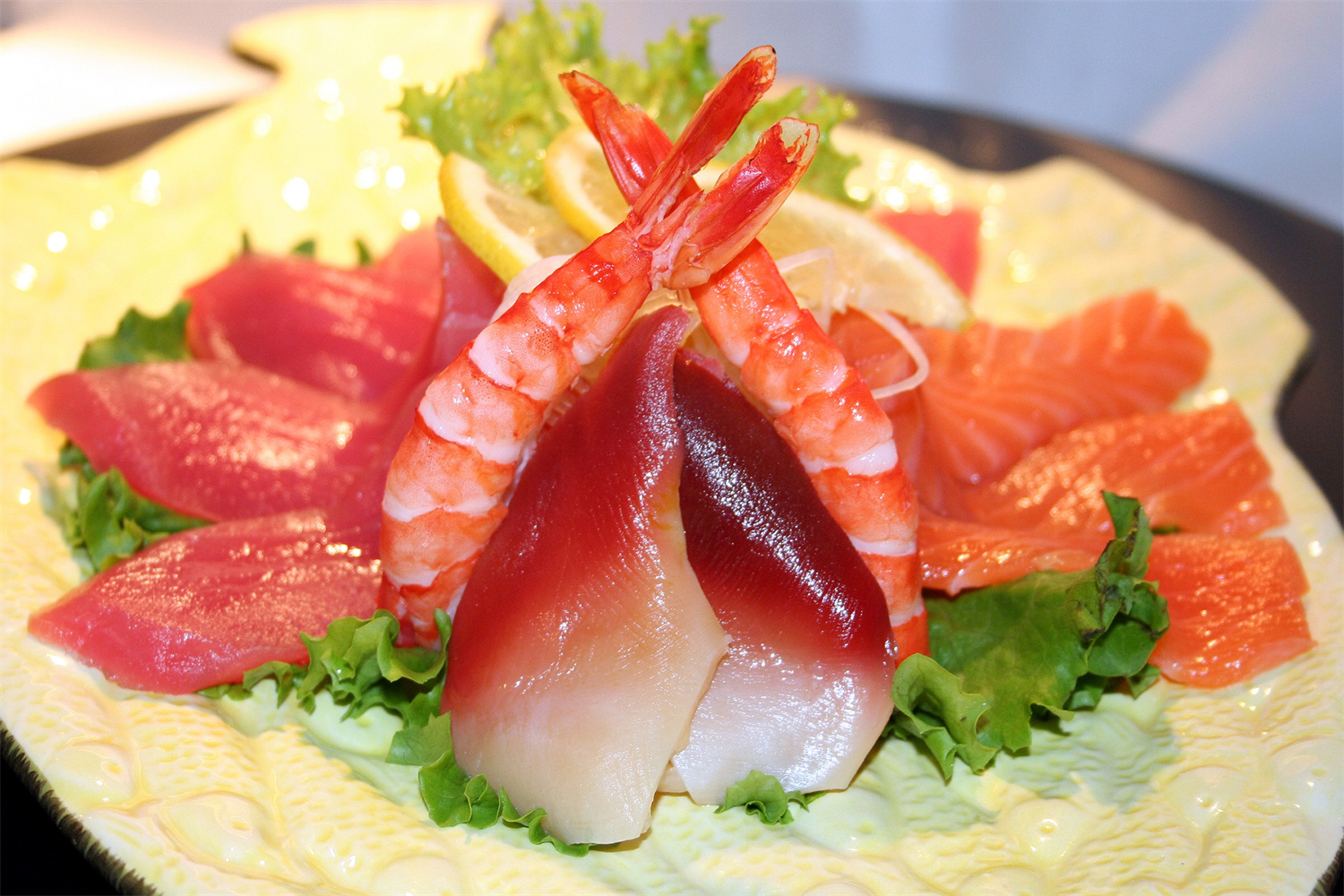 Sashimi platter with shrimp, tuna, salmon, and scallop on lettuce