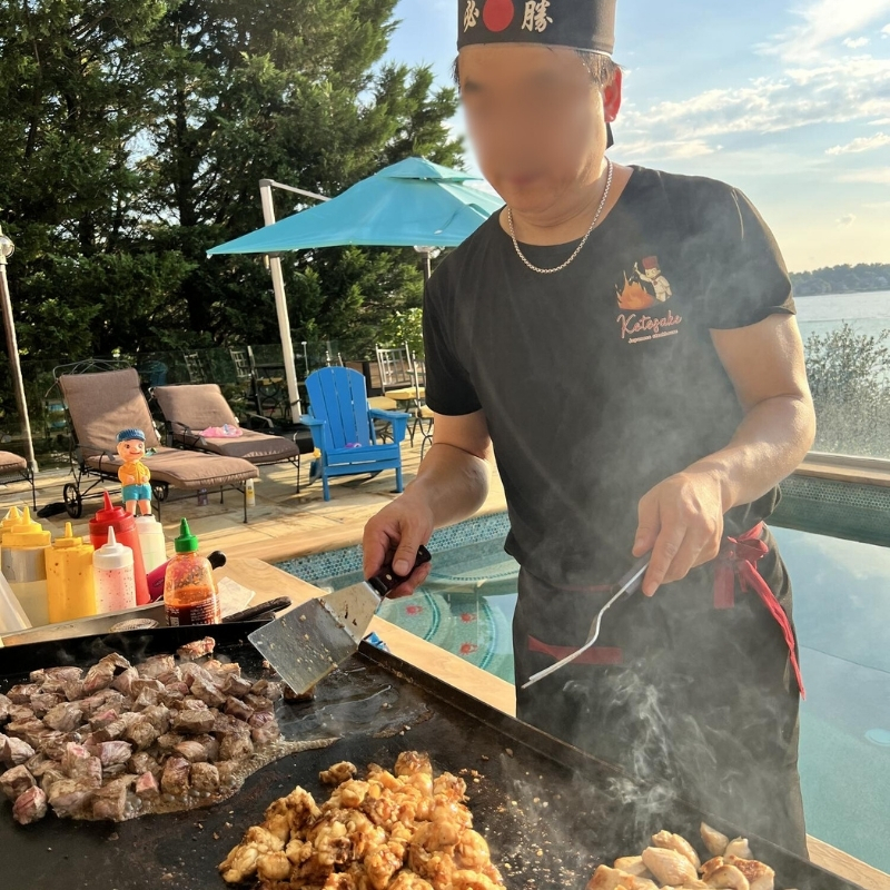 Hibachi-At-Yours-Hibachi-Restaurant-Chef-Grilling-Meat-Outdoor-Columbia Chef grills various meats outdoors at Hibachi At Yours,a Hibachi Restaurant in Columbia.