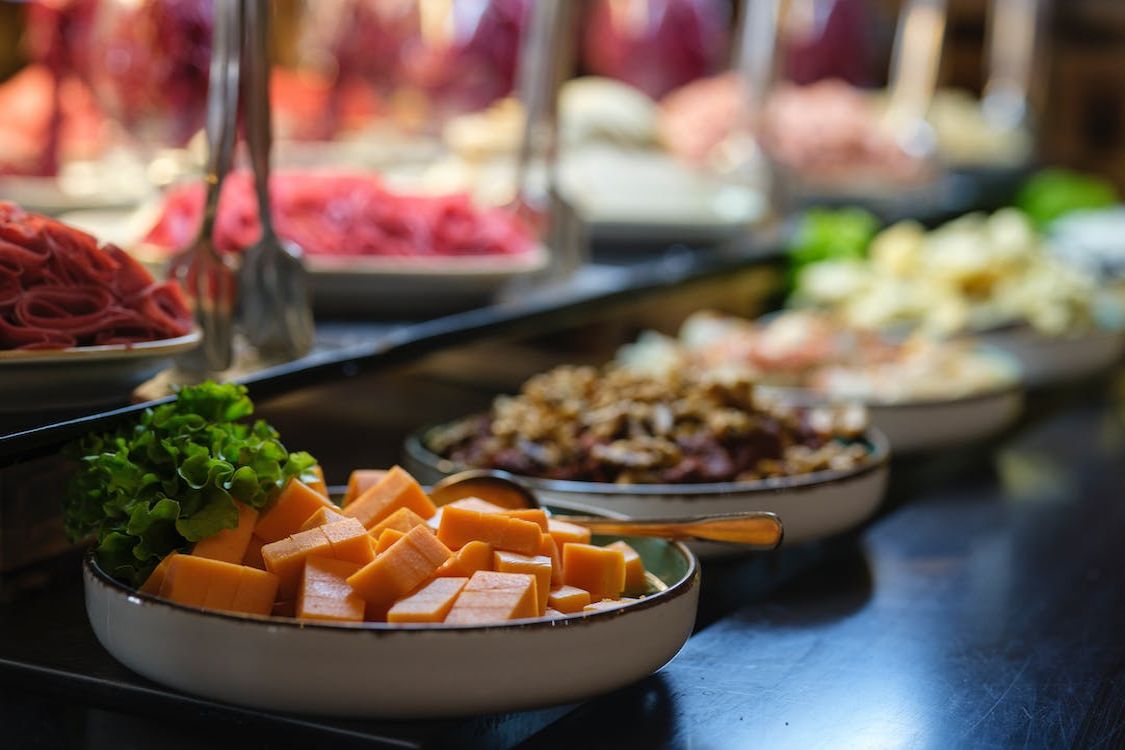Cheese and cold cuts buffet with cubed cheese and assorted meats.