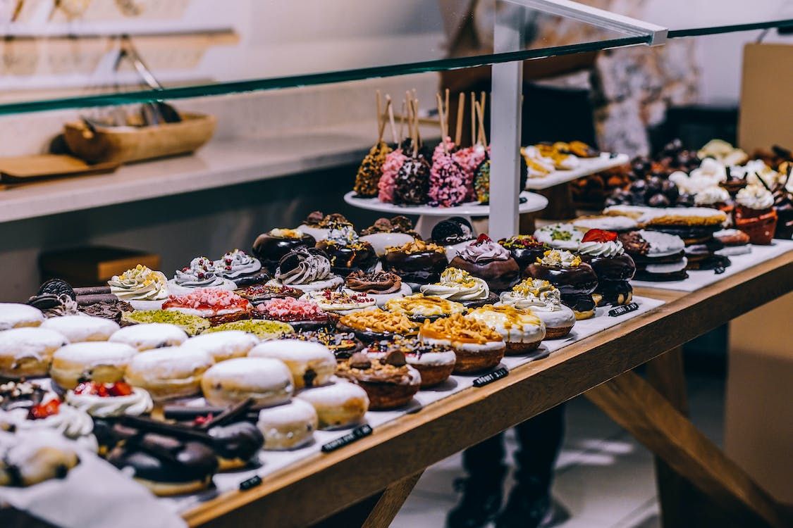Assorted donuts and pastries displayed on a wooden table.