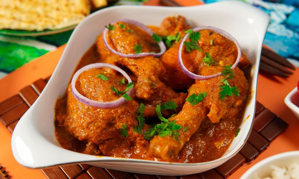 Chicken drumsticks in spiced curry sauce garnished with onions and cilantro at High Five Asian Street Food, a Asian restaurant in Ormond Beach