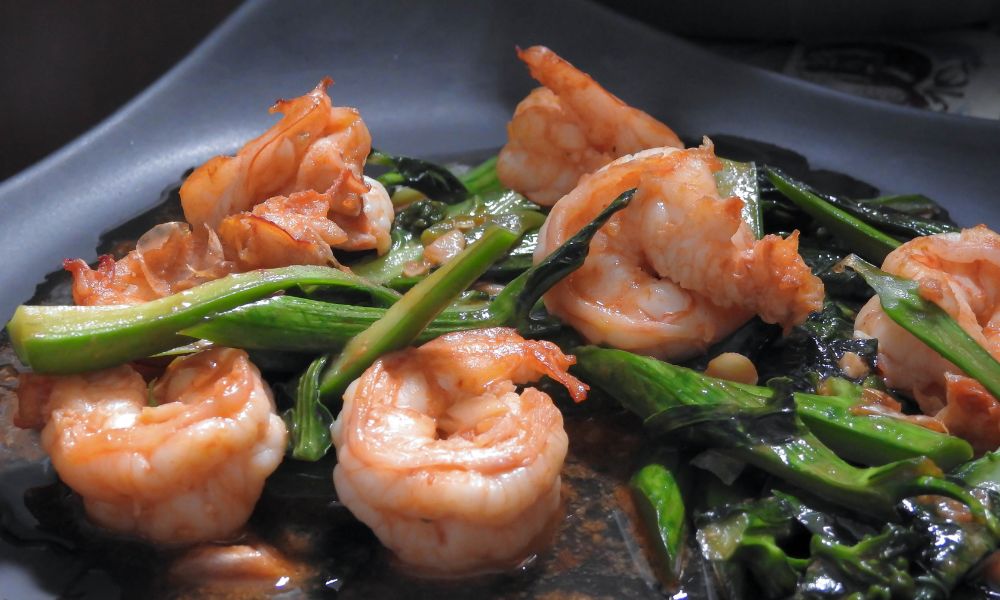 Stir-fried shrimp with leafy greens in a dark, savory sauce at High Five Asian Street Food, a Asian restaurant in Ormond Beach