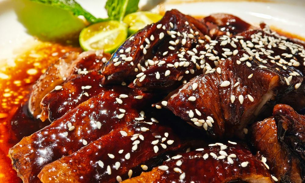 Sliced glazed duck breast with sesame seeds and lime wedges at High Five Asian Street Food, a Asian restaurant in Ormond Beach