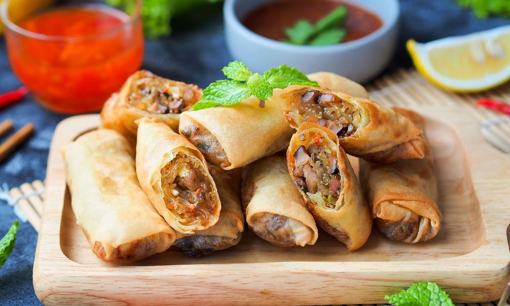 Fried spring rolls, some cut open to show filling, served with dipping sauces at High Five Asian Street Food, a Asian restaurant in Ormond Beach