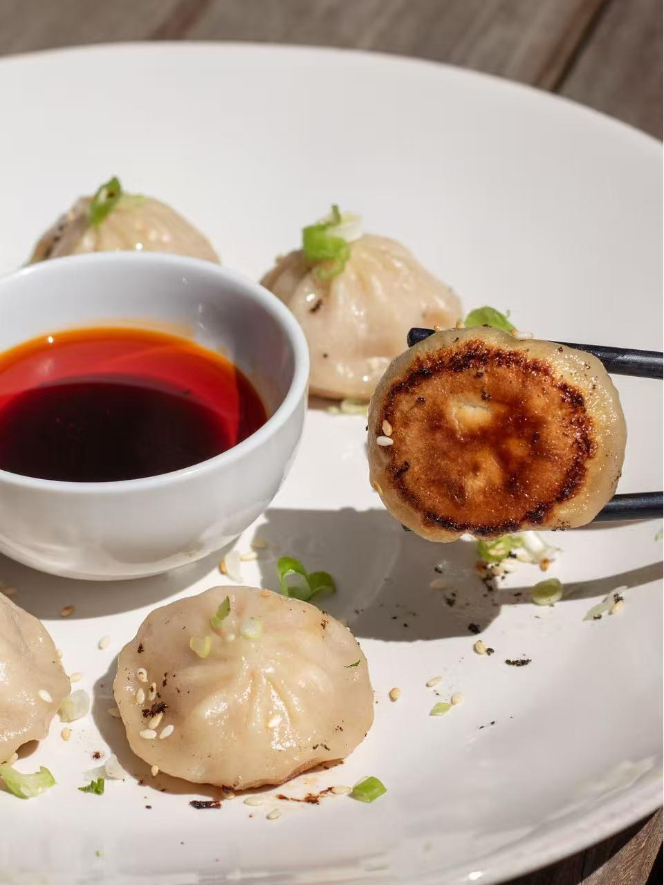 Pan - fried soup dumpling with dipping sauce at HK Bistro, a Chines Hong Kong Restaurant in Portland