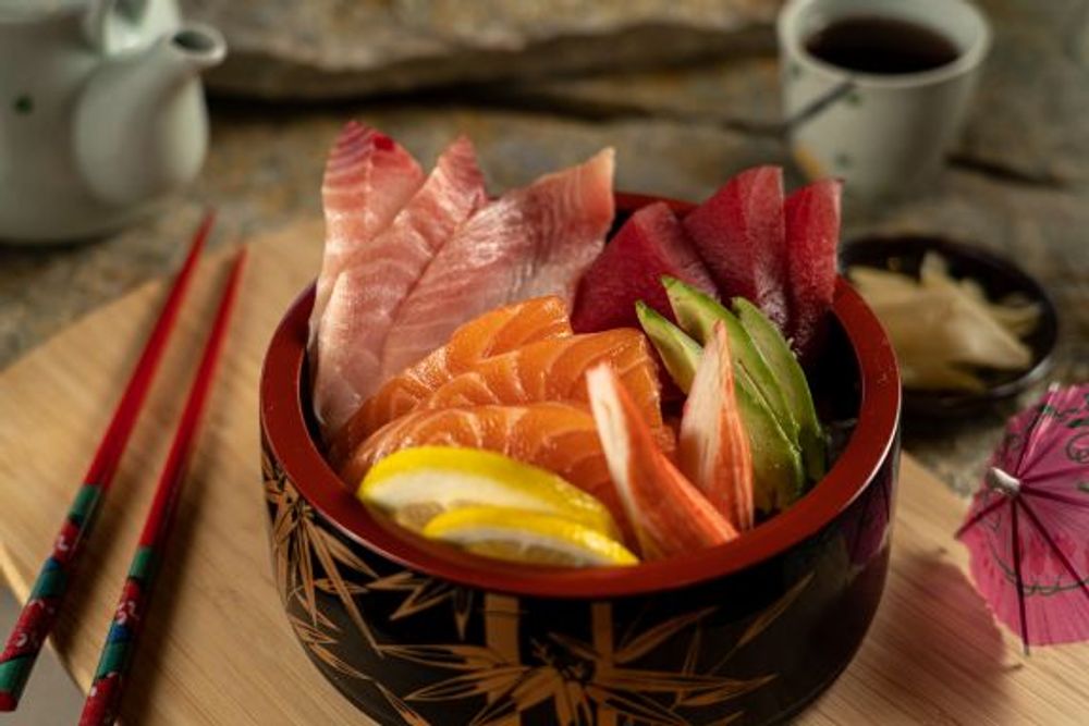 Chirashi sushi bowl filled with assorted raw fish, avocado and lemon slices at Hokkaido Sushi Bar, a Japanese Restaurant in Vancouver