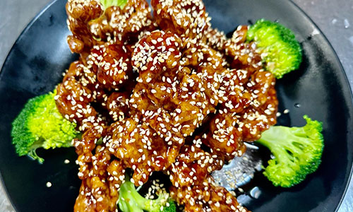 Glossy sesame chicken with sesame seeds and broccoli on a black plate 图片 2（酸辣土豆丝）