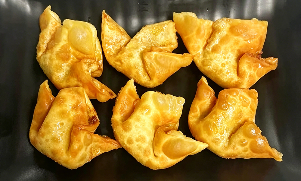 Crispy fried wontons served on a black plate at Hongda Dough House, a Chinese Restaurant in North Plains