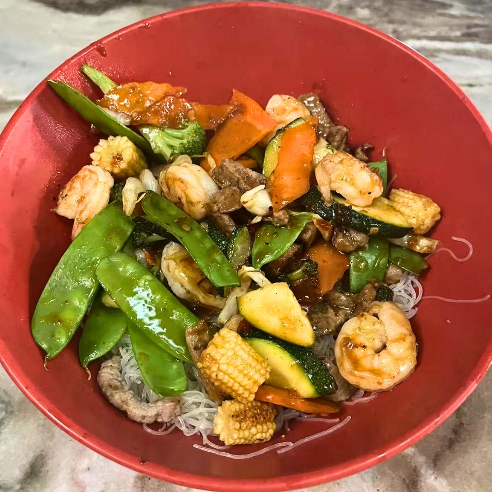A stir-fry bowl with beef, shrimp, mixed vegetables, and glass noodles at Hot Bowl Mongolian Grill, a Mongolian Barbecue Restaurant in Sugar Land