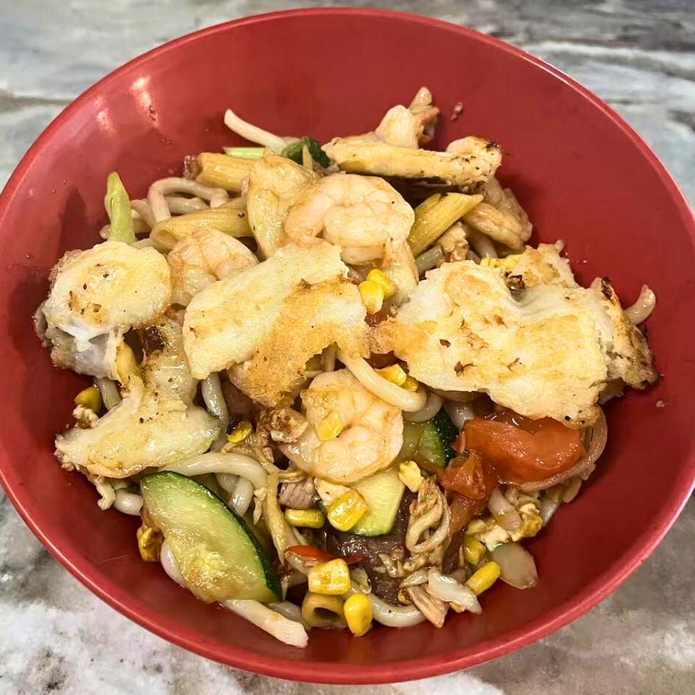 A stir-fry bowl with shrimp, meat, mixed vegetables, and udon noodles at Hot Bowl Mongolian Grill, a Mongolian Barbecue Restaurant in Sugar Land