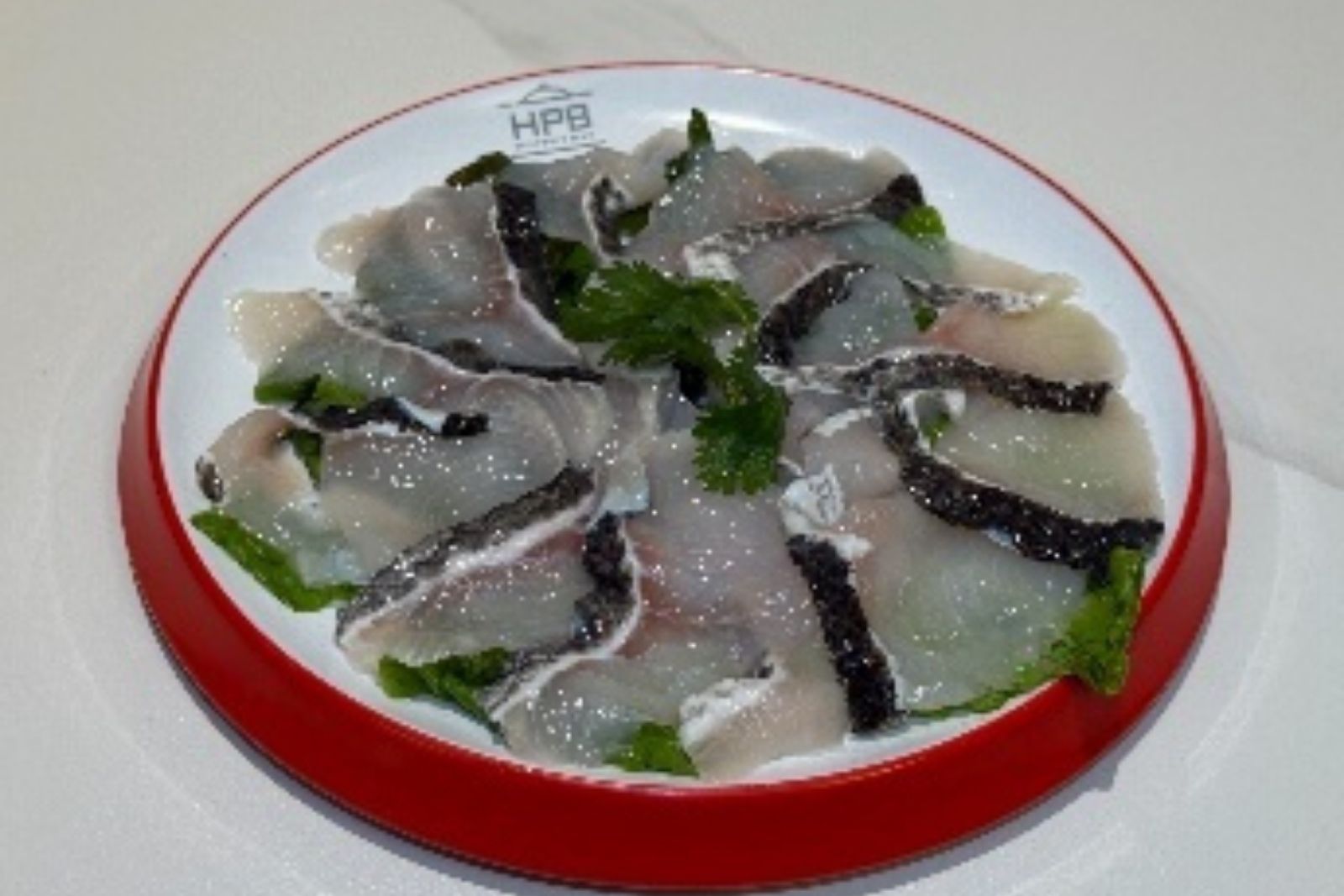 Fresh sliced fish hot pot ingredient garnished with cilantro at Hotpot Bay, a Chinese Hot Pot Restaurant in San Francisco