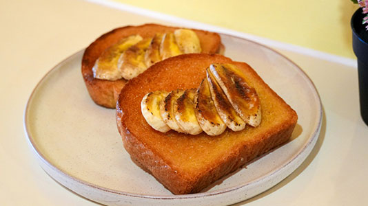 Two slices of thick toast topped with caramelized banana at TOZZARELLA, a Dessert restaurant in College Point