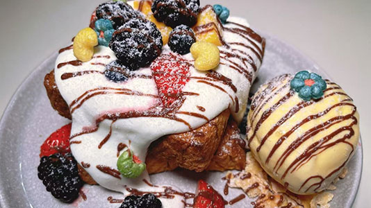 Berry-topped French toast with cream and ice cream at TOZZARELLA, a Dessert restaurant in College Point