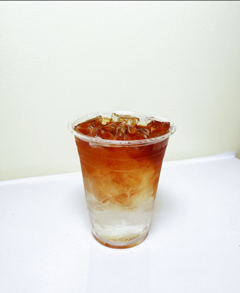 Layered iced tea drink in a clear plastic cup at TOZZARELLA, a Dessert restaurant in College Point