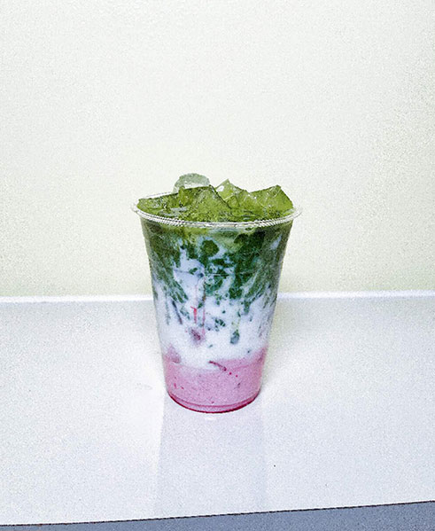 Layered matcha drink with pink base and ice cubes at TOZZARELLA, a Dessert restaurant in College Point