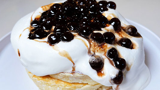 Fluffy souffle pancakes topped with boba and creamy sauce at TOZZARELLA, a Dessert restaurant in College Point