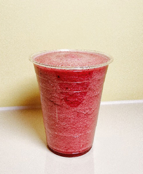 Bright red frozen berry smoothie in a clear cup at TOZZARELLA, a Dessert restaurant in College Point