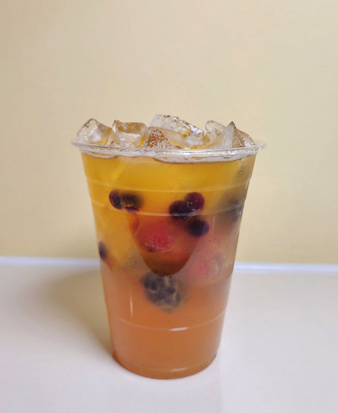 Iced fruit tea with berries and layered orange hue at TOZZARELLA, a Dessert restaurant in College Point