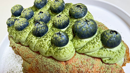 Matcha croissant pastry topped with fresh blueberries at TOZZARELLA, a Dessert restaurant in College Point
