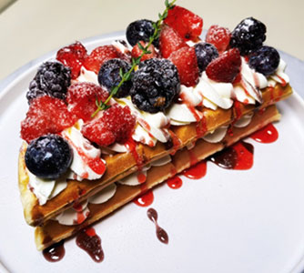 Berry-topped waffle sandwich with cream and berry sauce at TOZZARELLA, a Dessert restaurant in College Point