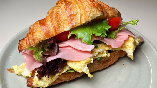 Ham and egg croissant sandwich with tomato and lettuce at TOZZARELLA, a Dessert restaurant in College Point