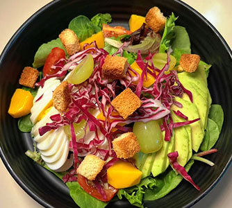 Fresh mixed salad with avocado, mango, grapes, croutons and greens at TOZZARELLA, a Dessert restaurant in College Point