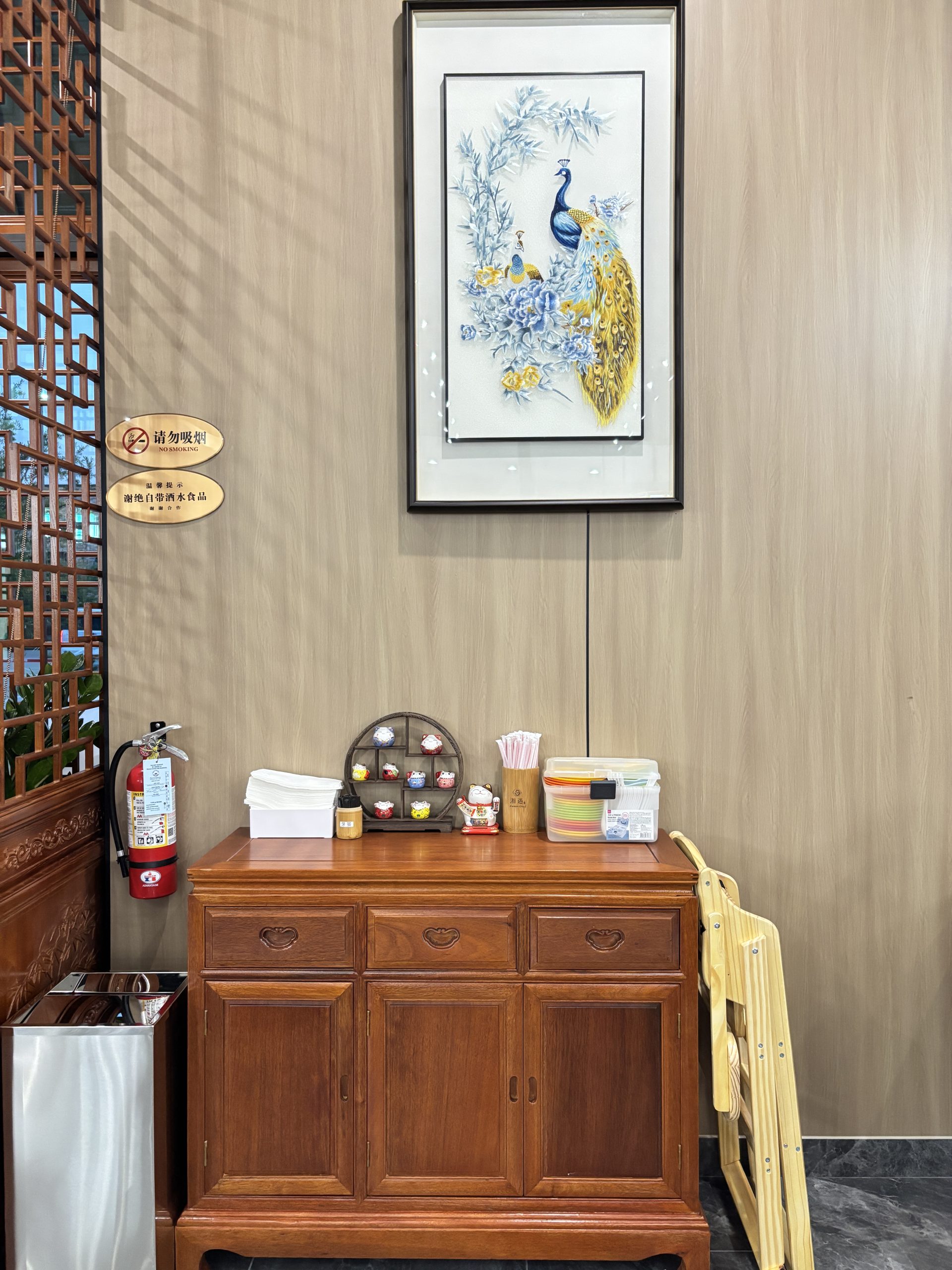 Interior decoration with peacock painting and wooden cabinet at Hunan Chef Xiang Yu, a Chinese Restaurant in Carrollton