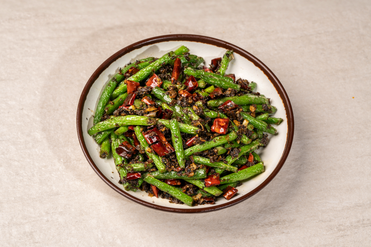 A bowl of dry-fried green beans with pickled vegetables, garlic, and red chilies at Hunan Heat, a Chinese Restaurant in Long Island City