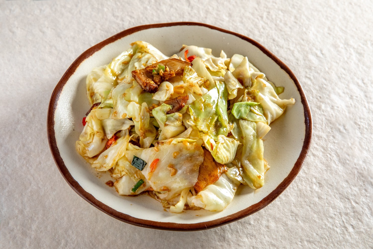 A plate of stir-fried hand-torn cabbage with pork belly, chilies, and scallions at Hunan Heat, a Chinese Restaurant in Long Island City